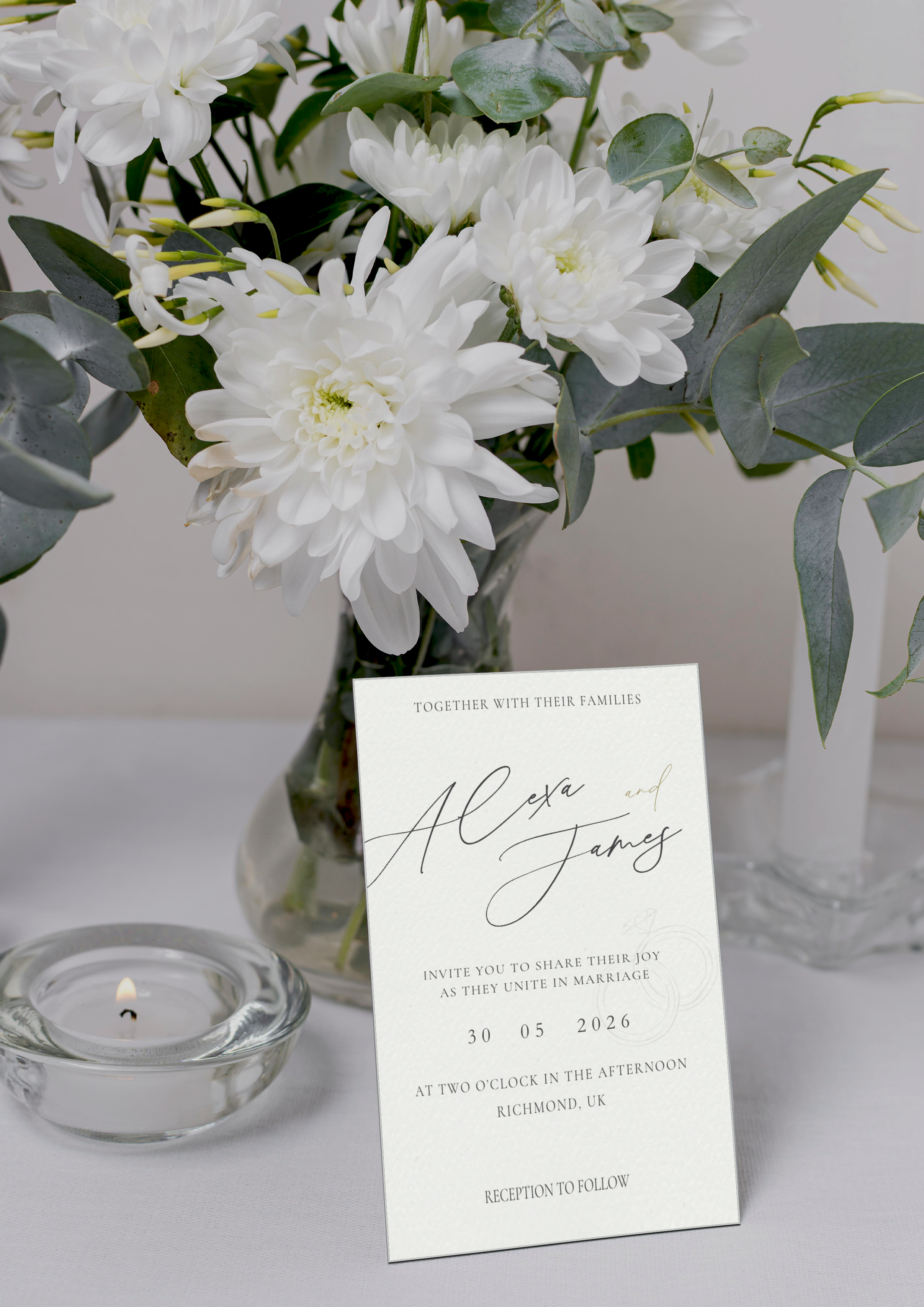 Wedding invitation card with white flowers and a candle on a table